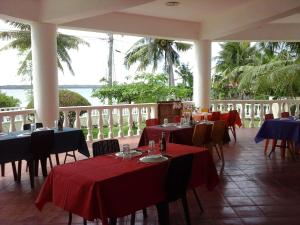 a restaurant with tables and chairs with red table cloth at Medellin Seaview Inn in Medellin