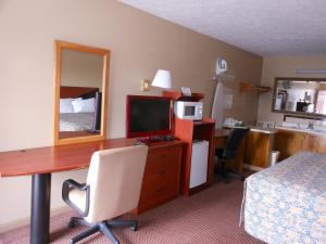 a hotel room with a desk with a computer and a bed at McClellan Inn in Anniston