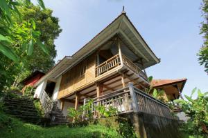 una casa con balcone e scale che la conducono di Melanting Cottages a Munduk