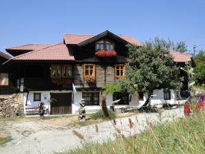 Kandaphery Guest Houses في Miykovtsi: منزل خشبي بسقف احمر