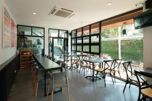 a restaurant with tables and chairs and windows at Wealth Boutique Hotel Chiang Mai in Chiang Mai