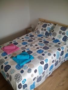 uma cama com um edredão e almofadas em Casa Das Gaivotas em Sesimbra
