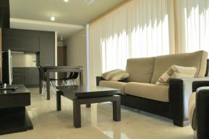 a living room with a couch and a table at L' Escala Resort in L'Escala