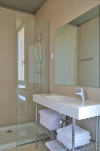 a bathroom with a sink and a shower and a mirror at L' Escala Resort in L'Escala