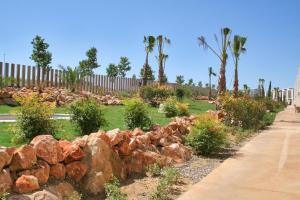 a pile of rocks in a park with palm trees at L' Escala Resort in L'Escala
