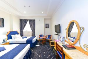 ドーハにあるCayam Hotelのベッドが2つと鏡があるホテルの部屋