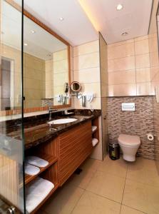 a bathroom with a sink and a toilet at Best Western Plus Pearl Creek in Dubai