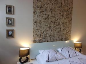1 dormitorio con 1 cama blanca y 2 lámparas en Chambres d'hôtes Le Gilliard en Chavanges