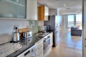 a kitchen with a counter top with a stove top oven at Horizon Bay 1404 in Bloubergstrand