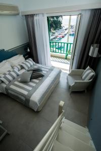 a bedroom with a bed and a large window at Alkyon Hotel in Patitiri