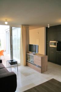 a living room with a couch and a tv at L' Escala Resort in L'Escala