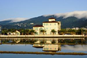 un grande edificio bianco con riflessione nell'acqua di Frontenac IIan a Jiaoxi