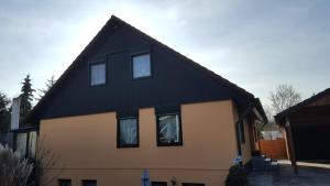 une maison avec un toit noir dans l'établissement Elegantes Apartment, à Wendelstein