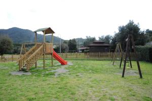 einen Spielplatz mit einer roten Rutsche im Hof in der Unterkunft Albergo Dei 10 Colori in Procchio