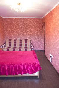 ヴィーンヌィツャにあるApartments near centerのベッドルーム1室(赤いベッドカバー付)