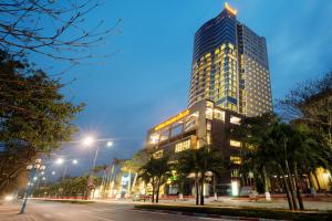 een hoog gebouw 's nachts met een straat voor bij Muong Thanh Grand Cua Lo Hotel in Cửa Lô
