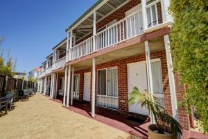 ein Backsteingebäude mit weißen Balkonen auf einer Straße in der Unterkunft The Jetty Resort in Esperance