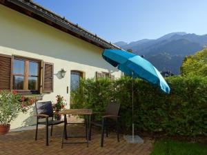 a table and chairs with a blue umbrella at Ferienwohnung Eylmann in Bad Reichenhall