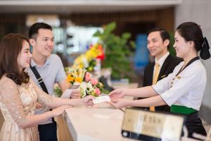 a group of people shaking hands at a counter at Muong Thanh Grand Cua Lo Hotel in Cửa Lô +50 photos
