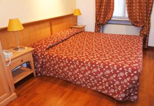 1 dormitorio con 1 cama y 1 lámpara en una mesa en Gorizia Inn, en Gorizia