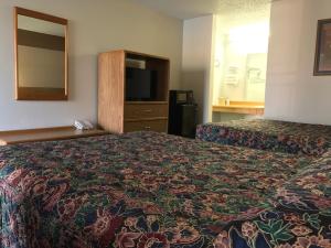 a hotel room with two beds and a television at American Inn Kansas City, KS in Kansas City