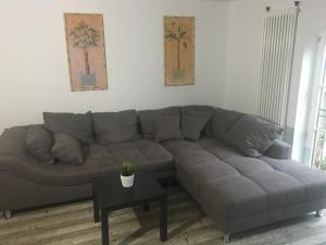 un sofá gris en una sala de estar con mesa en FEWO Schwerin-Zentrum en Schwerin