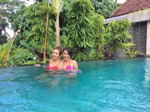 two women in the swimming pool at a resort at Ayu Bungalow 2 in Ubud +11 photos