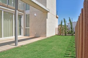 a yard with green grass next to a building at L' Escala Resort in L'Escala