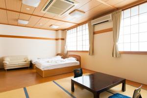 Habitación con 2 camas y mesa. en Watarase Onsen Hotel Yamayuri en Hongu