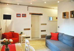 a living room with a blue couch and a red chair at Casetta in citta'- Seancity in Lucca