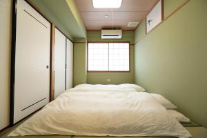 a large bed in a room with a window at Hotel Hana Ichirin in Kanazawa
