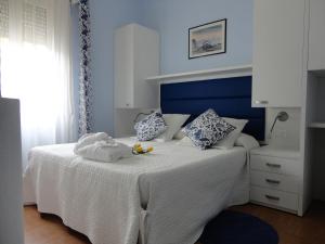 a bedroom with a white bed with a blue headboard at Hotel La Gioiosa in Rimini