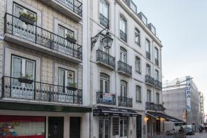 ein hohes weißes Gebäude mit Balkonen auf einer Straße in der Unterkunft Downtown Boutique Duplex in Lissabon