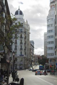 a city street with buildings and cars on the road at Noviciado Apartment in Madrid