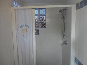 a shower with a white shower curtain in a bathroom at Hotel La Gioiosa in Rimini
