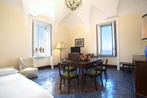 a hotel room with a table and chairs and a bed at La Ciucciara Holiday Homes in Massa Lubrense