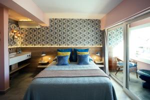 um quarto com uma cama grande e almofadas azuis em Picasso's Birthplace Views em Málaga