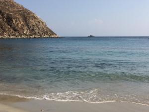 a beach with an island in the water at Beachfront Mykonos Guest House in Ornos +28 photos