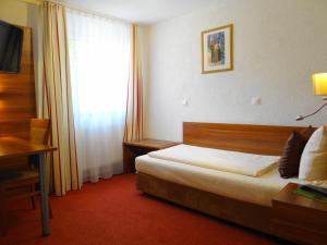 une chambre d'hôtel avec un lit et une fenêtre dans l'établissement Hotel Schützenhof mit Wellness, à Bürstadt