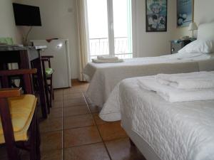 a hotel room with two beds and a television at Blue Dolphin in Batsi