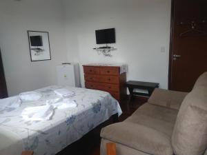 a bedroom with a bed and a chair at Casa Schneider in Gravatá