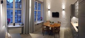 a dining room with a table and some windows at Apartment Into3City Old Town Gdansk in Gdańsk