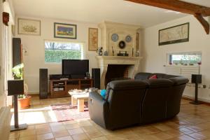 a living room with a couch and a fireplace at Chambre D'Hôtes le Phenix in Saint-Martin-du-Vivier