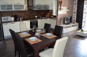 a kitchen with a wooden table with chairs and a dining room at Apartments Miočić in Zadar