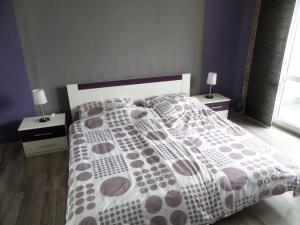 a bed with a polka dot bedspread and two night stands at Apartmán Trutnov in Trutnov