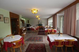 een restaurant met tafels en stoelen met rode en witte tafelkleden bij Pension Prantner in Innsbruck