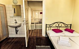 ein Bad mit einem Bett, einem Waschbecken und einem Spiegel in der Unterkunft St. Pauli Lodge Townhouse in Hamburg