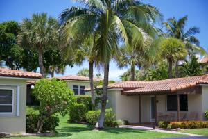 een huis met palmbomen ervoor bij Royal Flamingo Villas in Hillsboro Beach