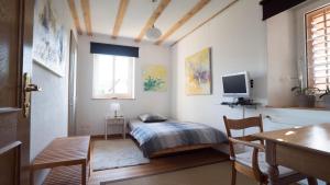Schlafzimmer mit einem Bett, einem Schreibtisch und einem TV in der Unterkunft B&B Casa Scaletto Turgi in Turgi