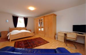 Schlafzimmer mit einem Bett, einem Schreibtisch und einem TV in der Unterkunft Gästehaus Perrin in Bliesmengen-Bolchen